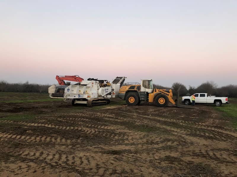 Heavy equipment clearing vegetation from a project site